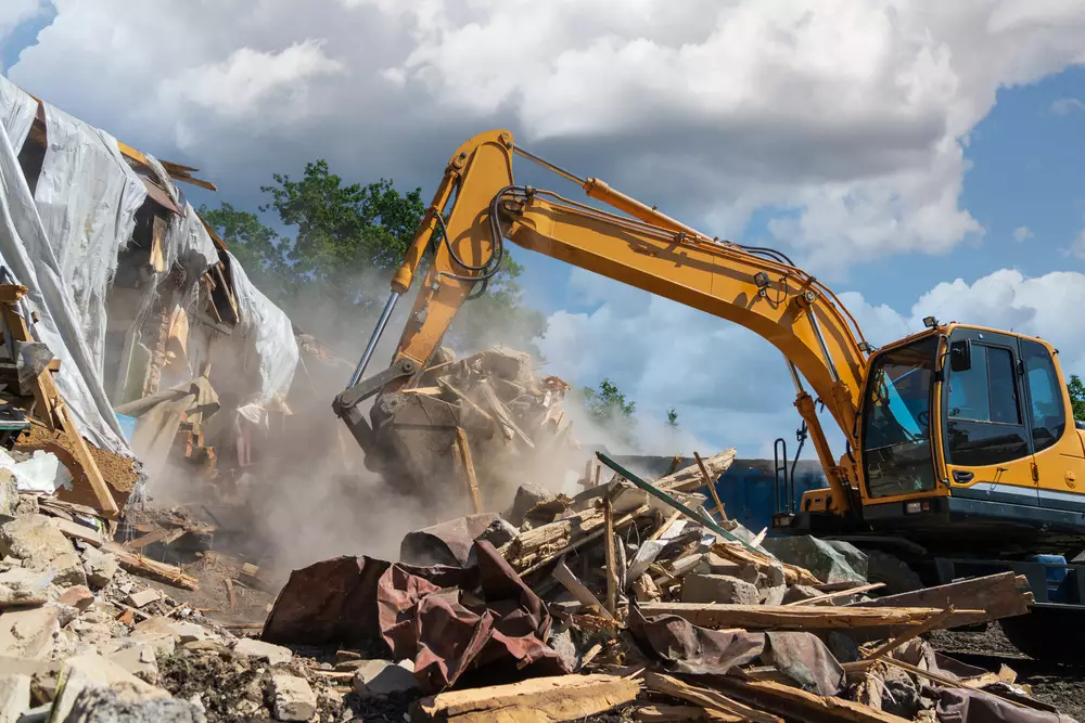 demolishing an old structure with a backhoe